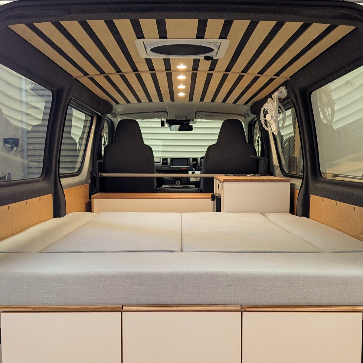 HiAce H200 fit-out in bed mode with custom Birch slat ceiling
